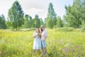 In summer, two women girlfriends are standing on a flower meadow. They are happy Royalty Free Stock Photo