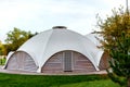 Summer-type cafe with cloth tent on the roof in the form of a dome with wooden entrance doors