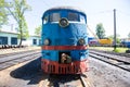 An old locomotive car is being repaired in a railway depot