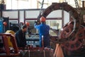 Workers stand behind the machines at the factory and work.