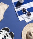 Summer vacation beach concept frame with retro sunglasses, striped towel and straw hat on the blue background. Royalty Free Stock Photo