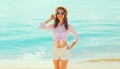 Summer vacation, beautiful happy smiling woman in straw hat on the beach on sea coast background on sunny day Royalty Free Stock Photo