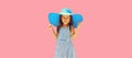 Summer vacation, beautiful little girl child in straw hat, striped dress posing on pink background Royalty Free Stock Photo