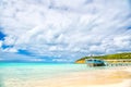 Summer vacation on caribbean. Sea beach with wooden shelter in antigua. Pier in turquoise water on cloudy sky background. Wanderlu Royalty Free Stock Photo