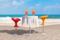 Summer Vacation Concept. Bar Modern Stools near Table with Red Tropical Cocktails on an Ocean Deserted Coast. 3d Rendering Royalty Free Stock Photo