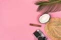 Summer vacation concept. Coconut, retro photo camera, hat and green palm leaves on pink background, flat lay Royalty Free Stock Photo