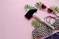 summer vacation concept. stylish pink sunglasses, modern swimsuit, phone on selfie stick, and green palm leaves on pink Royalty Free Stock Photo
