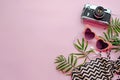 summer vacation concept. stylish pink sunglasses, modern swimsuit, photo camera,headphones and green palm leaves on pink Royalty Free Stock Photo