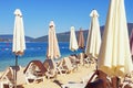 Summer vacation concept. Sunny day on beach. Lounge chairs with sun umbrellas. Montenegro, Bay of Kotor