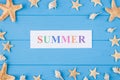 Summer vacation concept. Top above overhead view photo of word summer and seashells and seafish isolated on blue wooden background