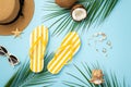 Summer vacation concept. Top view photo of sunhat yellow striped flip-flops sunglasses coconuts starfish shell bracelet earrings Royalty Free Stock Photo