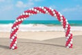 Summer Vacation Concept. White and Red Balloons in Shape of Arc, Gate or Portal on an Ocean Deserted Coast. 3d Rendering
