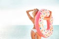 Summer Vacation. Enjoying suntan woman in white bikini with donut mattress near the sea. Royalty Free Stock Photo