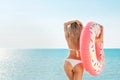 Summer Vacation. Enjoying suntan woman in white bikini with donut mattress near the swimming pool. Royalty Free Stock Photo