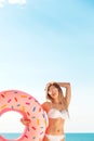 Summer Vacation. Enjoying suntan woman in white bikini with donut mattress near the swimming pool. Royalty Free Stock Photo