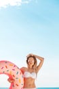 Summer Vacation. Enjoying suntan woman in white bikini with donut mattress near the swimming pool. Royalty Free Stock Photo