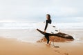 Summer vacation and extreme sport concept. Young woman walking with surfboard on ocean beach, full length, free space Royalty Free Stock Photo