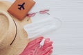 Summer vacation 2020. Face mask, pink gloves, antiseptic and disinfectant, passport, sunglasses, straw hat on white background. Royalty Free Stock Photo