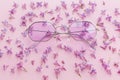 summer vacation and festival concept. stylish purple boho sunglasses on pink background with lilac flowers. creative trendy flat Royalty Free Stock Photo