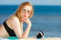 Summer vacation Girl with phone tanning on beach Royalty Free Stock Photo