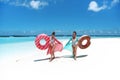 Summer Vacation. Happy free two women with Inflatable donut float mattress. Girls wearing Chiffon Beach Dress enjoying exotic Royalty Free Stock Photo