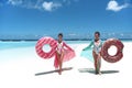 Summer Vacation. Happy free two women with Inflatable donut float mattress. Girls wearing Chiffon Beach Dress enjoying exotic Royalty Free Stock Photo