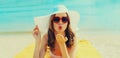 Summer vacation, happy relaxing young woman blowing her lips sends kiss in red heart shaped sunglasses, straw hat lying on sand on Royalty Free Stock Photo