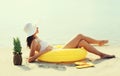 Summer vacation, happy relaxing young woman lying on sand on the beach with swimming inflatable ring on sea background Royalty Free Stock Photo