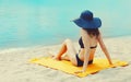 Summer vacation, happy relaxing young woman with straw hat lying on sand on the beach on sea background Royalty Free Stock Photo