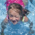 Summer vacation, healthy lifestyle and happy childhood concept. Top view of cute child girl having fun in swimming pool. Close up Royalty Free Stock Photo