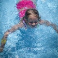 Summer vacation, healthy lifestyle and happy childhood concept.Young child girl splashing in swimming pool and having fun leisure Royalty Free Stock Photo