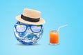 Blue planet earth wear weave hat and sunglasses with orange juice put on blue background. Royalty Free Stock Photo