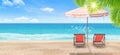 Beach chair and umbrella on sand beach with beautiful seascape view of sea and blue sky in the background. Royalty Free Stock Photo