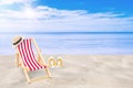 Beach chair, weave hat and white sandal flip flop on sand beach with beautiful seascape view of sea and blue sky in the background Royalty Free Stock Photo