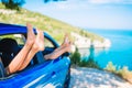 Summer vacation, holidays, travel, road trip and people concept - close up of little girl feet showing from car window Royalty Free Stock Photo