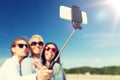 Women with selfie stick and smartphone on beach