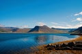 Summer vacation in isafjordur, iceland. Hilly coastline on sunny blue sky. Mountain landscape seen from sea. Discover