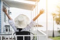 Summer vacation lifestyle with young girl wearing sunscreen hat on sunny day relaxing taking it easy happily sitting on the porch