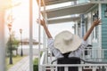 Summer vacation lifestyle with young girl wearing sunscreen hat on sunny day relaxing taking it easy happily sitting on the porch