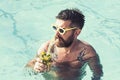 Summer vacation at Miami beach or Maldives. Pool party with hipster in blue water. Man swimming and drink alcoholic Royalty Free Stock Photo