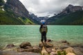 Lake Louise, Banff National Park, Alberta, Canada. Backpack hiker looks on amazing landscape. Active life.