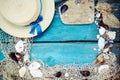 Summer vacation relaxation background theme with seashells, fishing net, hat, rope, stones and weathered wood blue background with Royalty Free Stock Photo