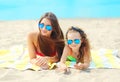 Summer vacation, relaxation, travel - portrait mother and child lying on beach