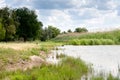 Summer vacation on the river bank. Hunting for wild ducks. White clouds over the forest lake. Royalty Free Stock Photo