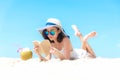 Summer Vacation. Smelling asian women relaxing, reading book and drinking coconut cocktail on the beach, so happy and luxury in ho Royalty Free Stock Photo