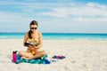 Summer Vacation. Smelling tourist women relaxing and reading book with sunglasses in beach Royalty Free Stock Photo