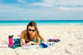 Summer Vacation. Smelling tourist women relaxing and reading book with sunglasses in beach Royalty Free Stock Photo