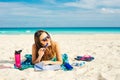 Summer Vacation. Smelling tourist women relaxing and reading book with sunglasses in beach Royalty Free Stock Photo