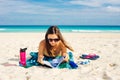 Summer Vacation. Smelling tourist women relaxing and reading book with sunglasses in beach Royalty Free Stock Photo