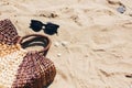 Summer Vacation. Stylish sunglasses and straw bag on sandy beach with sea shells. Girl accessory on the beach. Hello summer Royalty Free Stock Photo